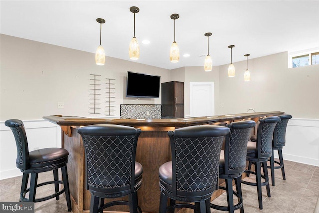 bar featuring tasteful backsplash and pendant lighting