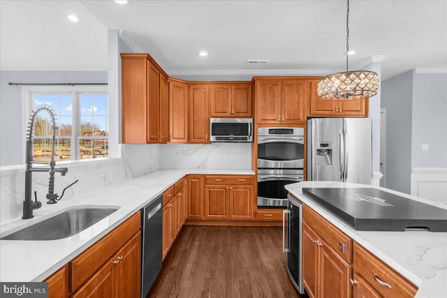 kitchen featuring dark wood-type flooring, hanging light fixtures, sink, appliances with stainless steel finishes, and a notable chandelier