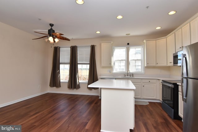 kitchen featuring a kitchen island, appliances with stainless steel finishes, dark wood-type flooring, and a healthy amount of sunlight