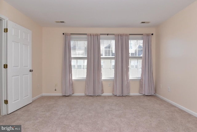 unfurnished room with a healthy amount of sunlight and light colored carpet