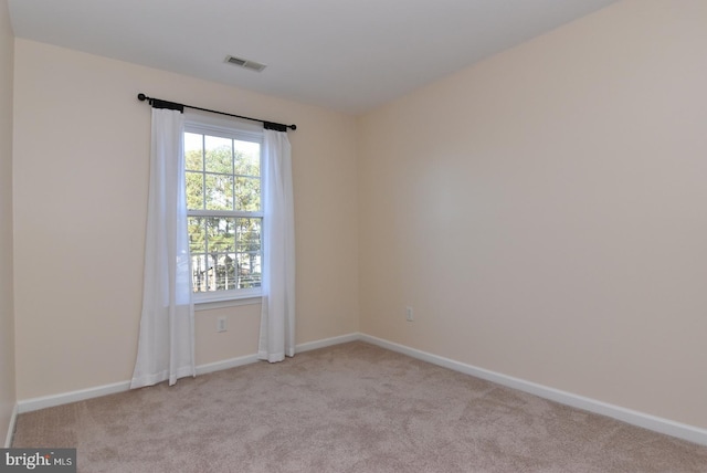 spare room featuring light carpet