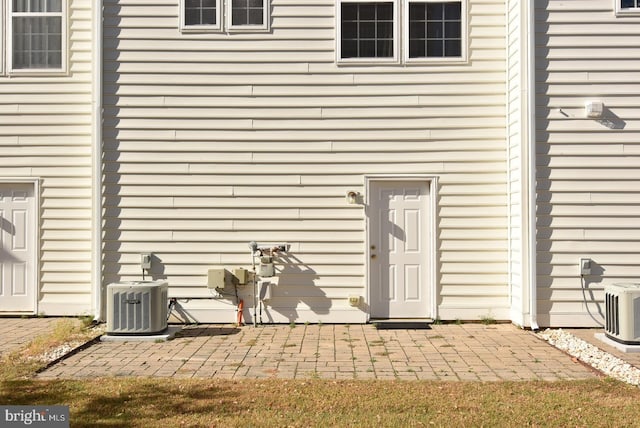 property entrance with central air condition unit and a patio