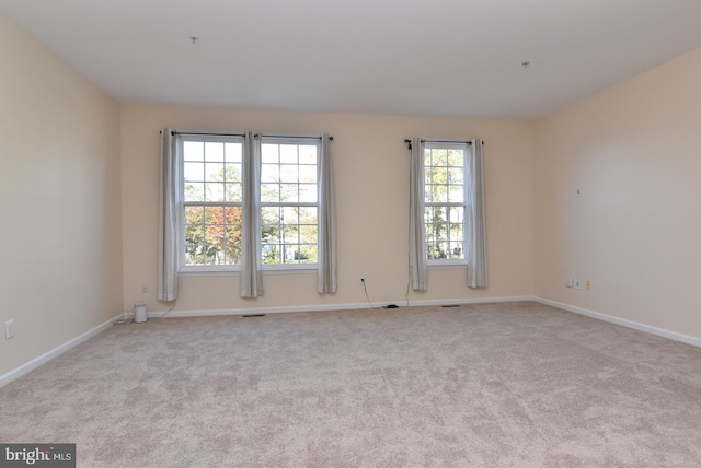 carpeted empty room with plenty of natural light