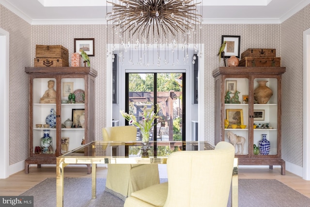 dining room with light wood-type flooring, a notable chandelier, and crown molding