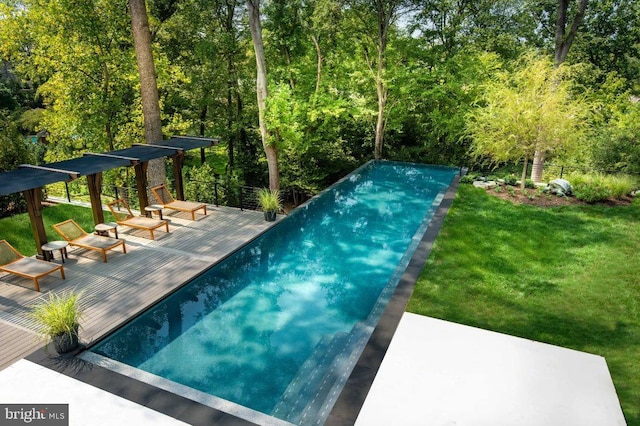 view of swimming pool with a lawn and a wooden deck