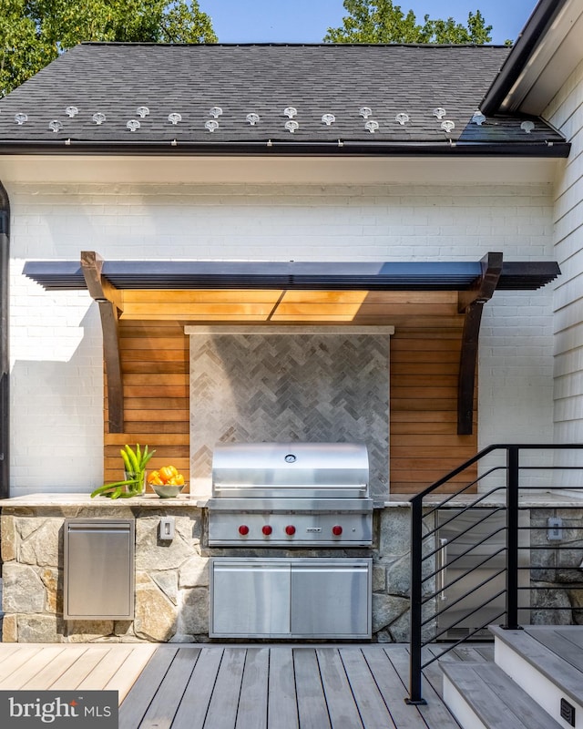 wooden terrace featuring an outdoor kitchen and a grill