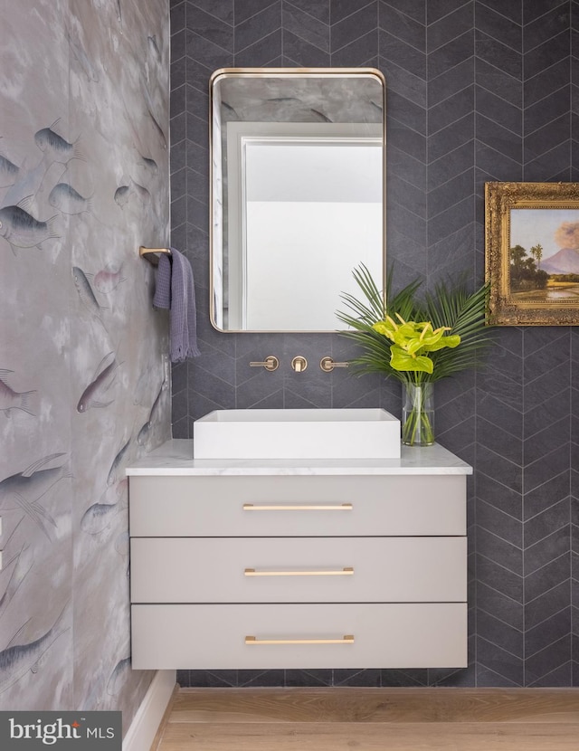 bathroom featuring tile walls, wood-type flooring, and vanity