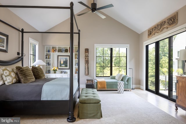 bedroom with high vaulted ceiling, a barn door, multiple windows, and ceiling fan