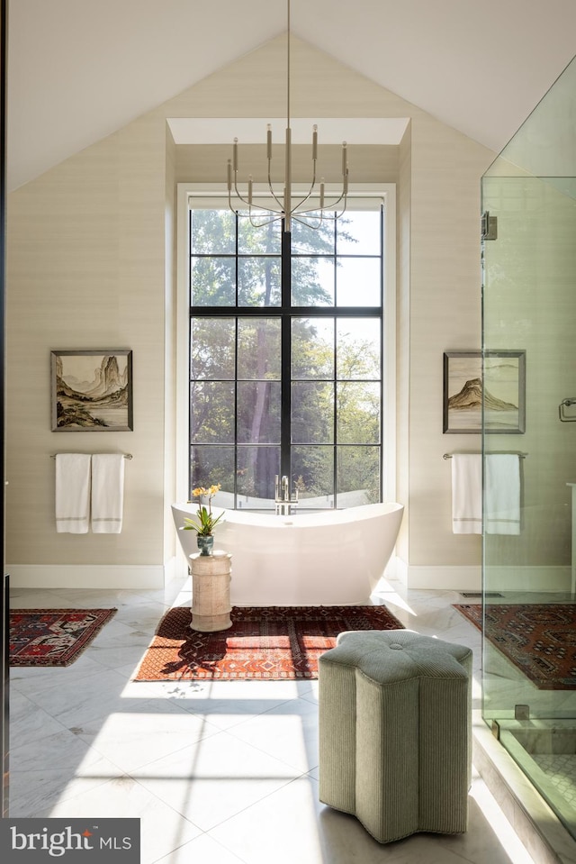 sitting room with a chandelier, plenty of natural light, and vaulted ceiling