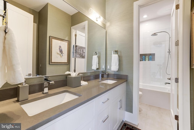 full bathroom featuring tile patterned flooring, vanity, tiled shower / bath combo, and toilet