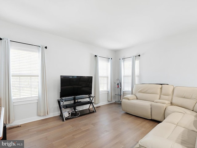 living room featuring light hardwood / wood-style flooring and a healthy amount of sunlight