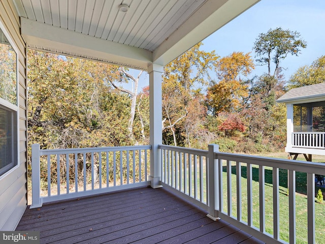 wooden terrace featuring a yard