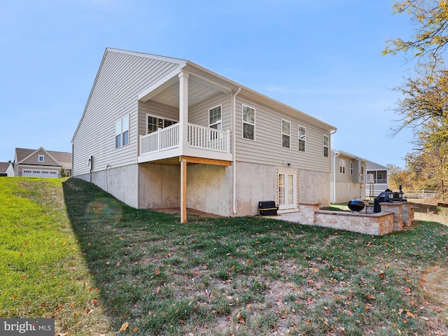 back of house with a patio area and a lawn