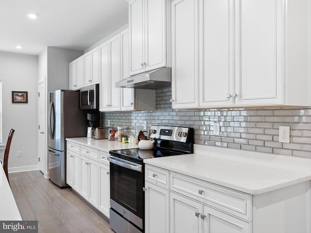 kitchen featuring appliances with stainless steel finishes, light hardwood / wood-style flooring, white cabinets, and decorative backsplash