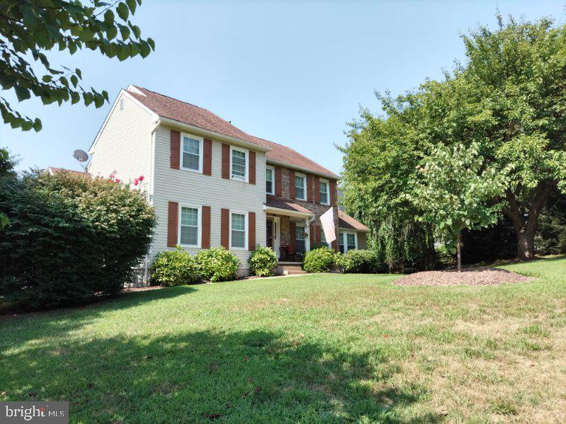 colonial-style house with a front lawn