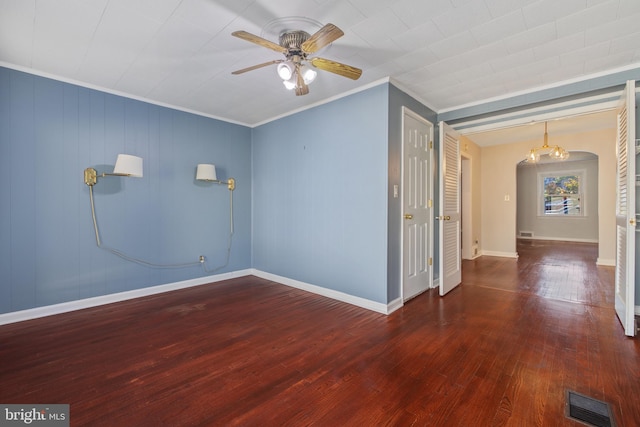 unfurnished room with dark wood-type flooring, ornamental molding, and ceiling fan with notable chandelier