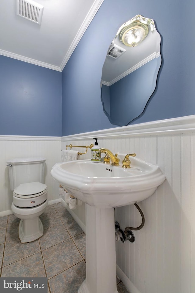 bathroom featuring visible vents, a wainscoted wall, toilet, ornamental molding, and tile patterned floors