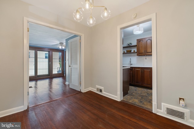 unfurnished dining area featuring dark wood-type flooring, ceiling fan, ornamental molding, and sink