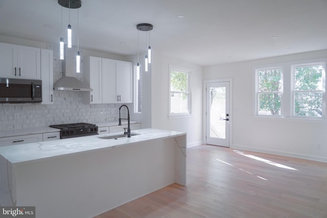 kitchen with gas stove, white cabinets, and decorative light fixtures