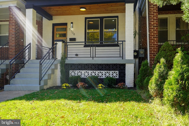 view of exterior entry with a yard