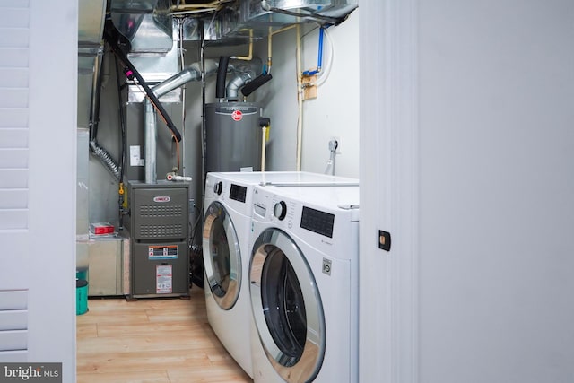 laundry room featuring light hardwood / wood-style flooring, water heater, and washing machine and clothes dryer