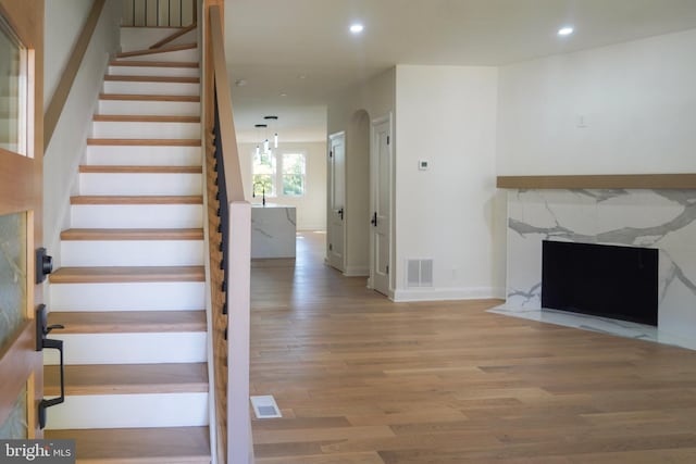 stairs with hardwood / wood-style floors, sink, and a fireplace