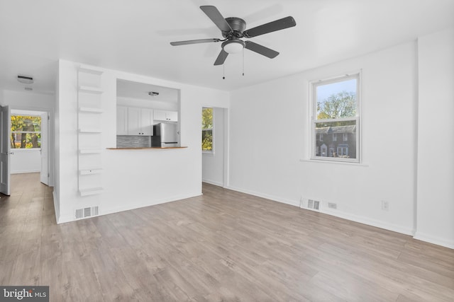 unfurnished living room featuring light hardwood / wood-style floors, plenty of natural light, and ceiling fan