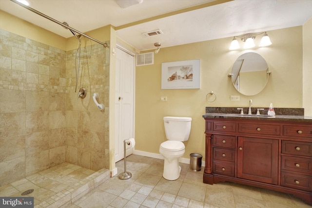 bathroom featuring vanity, toilet, and tiled shower