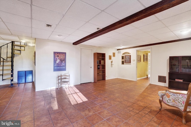 unfurnished living room featuring a paneled ceiling, beam ceiling, and tile patterned flooring