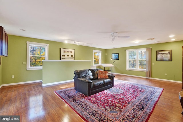 living room featuring ceiling fan, hardwood / wood-style flooring, and a wealth of natural light