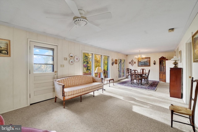 living room with crown molding, carpet flooring, plenty of natural light, and ceiling fan with notable chandelier