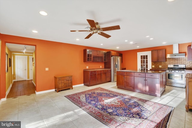 kitchen featuring decorative backsplash, wall chimney range hood, stainless steel appliances, a center island, and light tile patterned floors