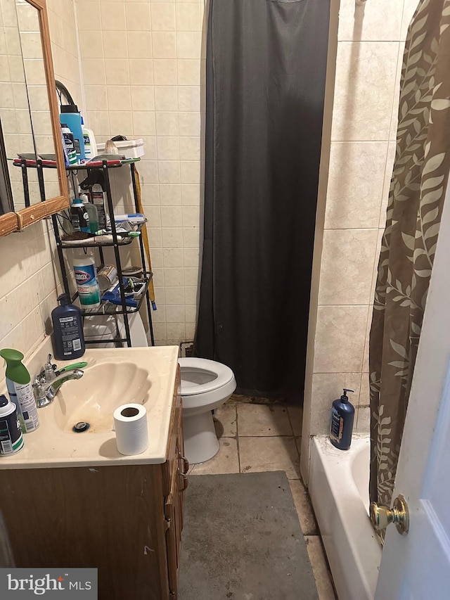 full bathroom featuring tile patterned flooring, shower / bathtub combination with curtain, vanity, toilet, and tile walls