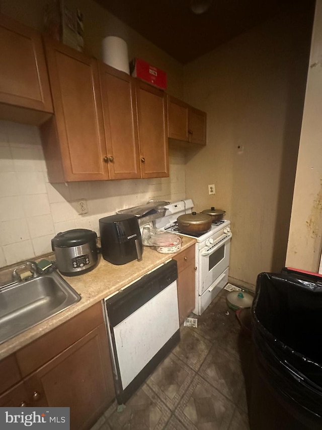 kitchen featuring backsplash, white appliances, and sink