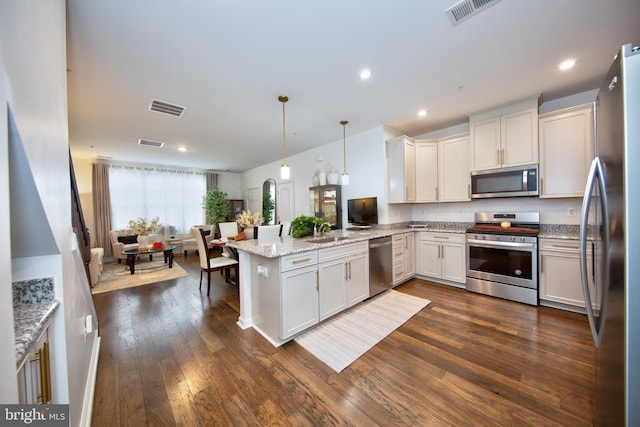 kitchen featuring pendant lighting, appliances with stainless steel finishes, dark hardwood / wood-style floors, and white cabinetry