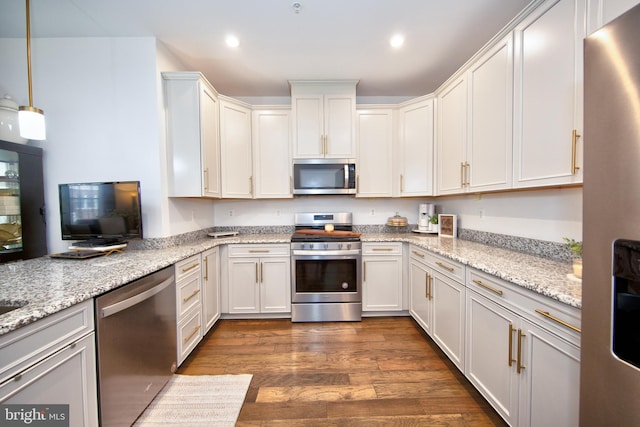 kitchen featuring light stone countertops, dark hardwood / wood-style flooring, hanging light fixtures, stainless steel appliances, and white cabinets