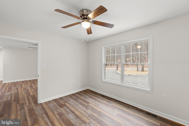 unfurnished room with ceiling fan and dark wood-type flooring