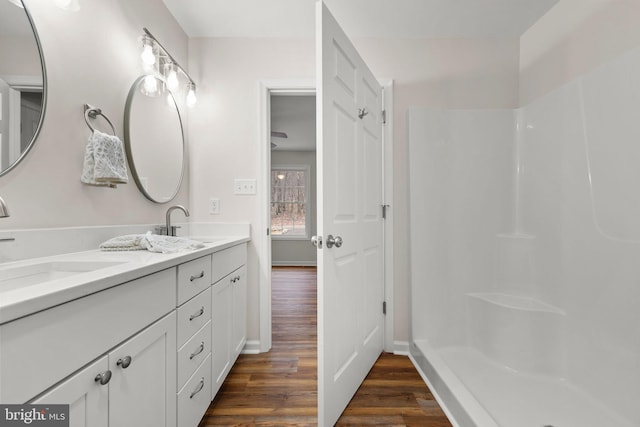 bathroom with a shower, vanity, and hardwood / wood-style flooring