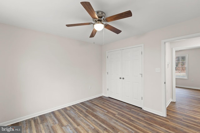 unfurnished bedroom with ceiling fan, dark hardwood / wood-style flooring, and a closet