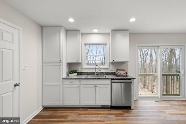 kitchen featuring hardwood / wood-style floors, dishwasher, white cabinets, sink, and stone countertops