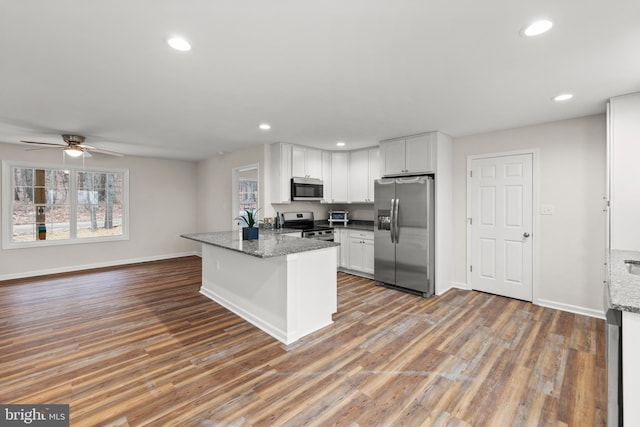 kitchen featuring ceiling fan, white cabinetry, stainless steel appliances, and stone counters