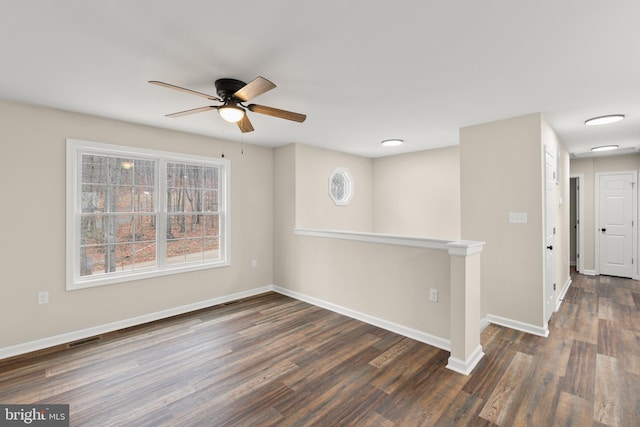 empty room featuring ceiling fan and dark hardwood / wood-style flooring