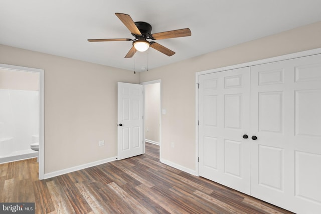 unfurnished bedroom with ensuite bathroom, ceiling fan, dark hardwood / wood-style floors, and a closet