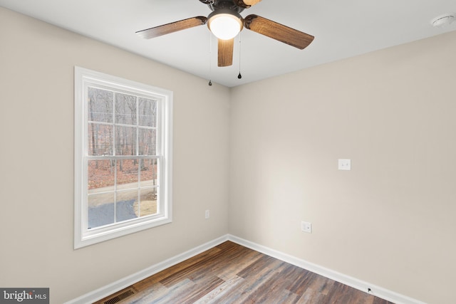 spare room featuring ceiling fan and dark wood-type flooring