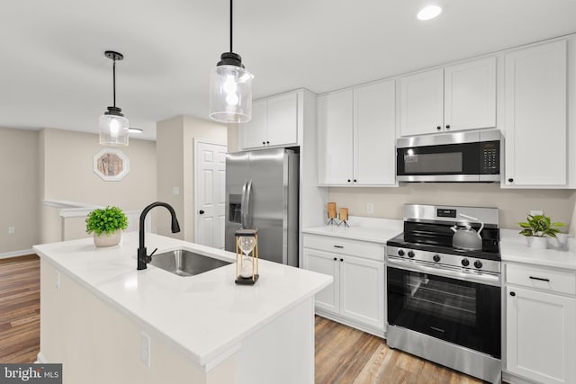 kitchen with white cabinetry, a kitchen island with sink, sink, and stainless steel appliances