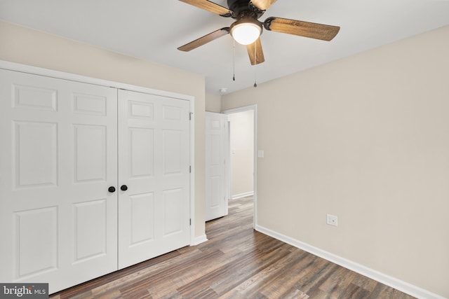 unfurnished bedroom featuring dark hardwood / wood-style flooring, ceiling fan, and a closet