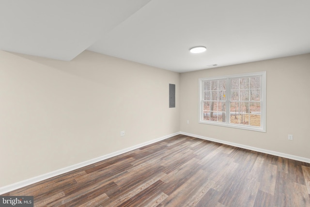 spare room featuring dark hardwood / wood-style flooring and electric panel