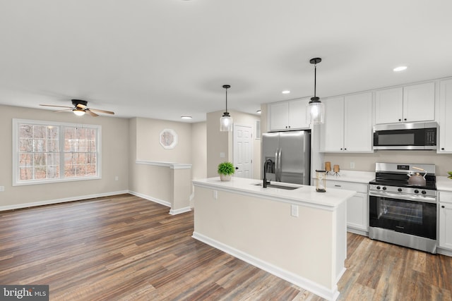 kitchen featuring a center island with sink, white cabinets, pendant lighting, and appliances with stainless steel finishes