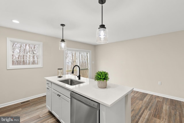 kitchen with stainless steel dishwasher, a kitchen island with sink, sink, decorative light fixtures, and white cabinetry