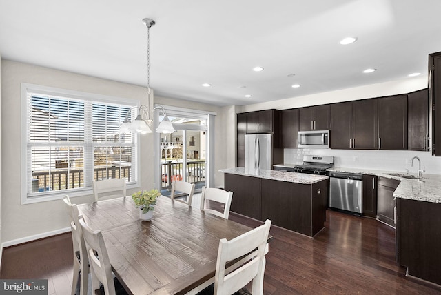 dining area featuring sink, a notable chandelier, and dark hardwood / wood-style floors